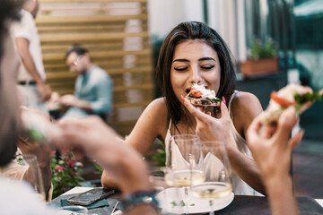 A young woman savoring a delicious pizza slice, enjoying an al fresco dining experience with...