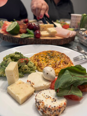variety of cheese and salad on plate on breakfast or lunch table
