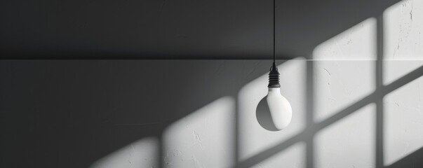 Hanging light bulb with shadows on wall