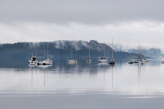 Boats in front of the shore of Cowichan Bay during a winter season on Vancouver Island in British Columbia, Canada