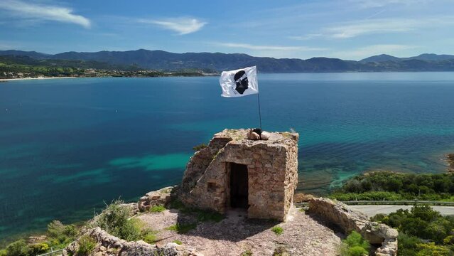 Corsica. Tower with the flag of Corsica fluttering in the wind
