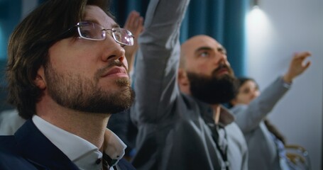 Diverse journalists raise hands at press campaign in the conference hall. Press workers ask...