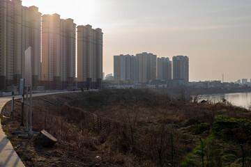 High-rise apartment tower buildings on the banks of the river in Xiantao, China at dusk