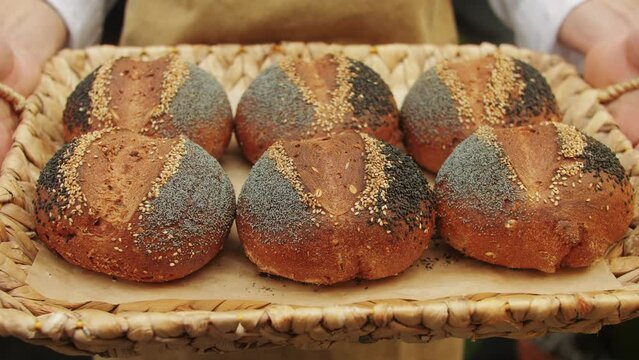 The baker holds in hands a of fresh bread close-up. Artisan bread is making by skill bakers using natural and high-quality ingredients. Food with health and flavour benefits. 