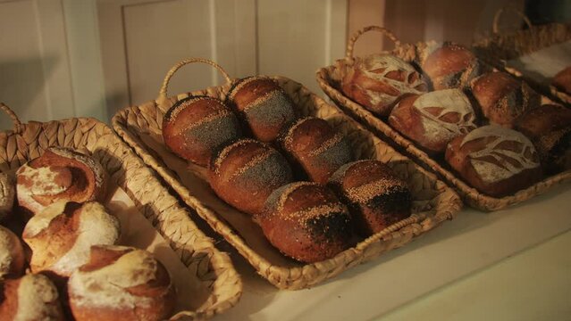 Fresh artesian bread on bakery shop close-up. Bread with black poppy garnish on top and white flour on top. Artisan bread is making by skill bakers using natural and