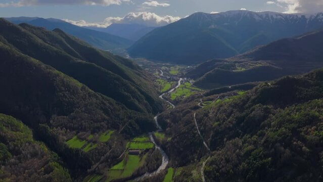 Drone footage reveals terraced fields, a winding river, and a village in the Basque Country, Spain, between forest-covered mountains