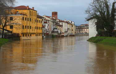 Obraz premium Floodwaters surge past houses threatening to overflow in VICENZA ITALY
