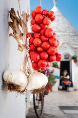 An old lady prepares the tomato puree during summer in the archeological village of Alberobello,...