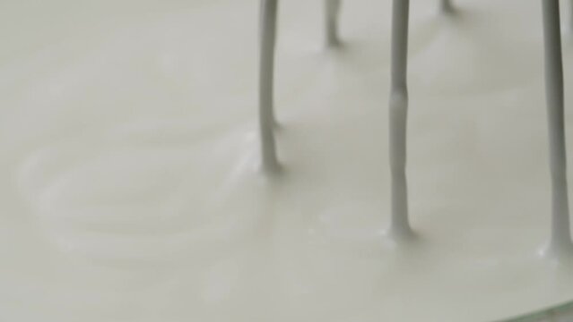 White creamy sauce texture close-up. Dipping and whisking by corolla a white yogurt macro. Dairy products concept. 