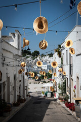 Curious alley setting with straw hats in Alberobello, puglia, itally.