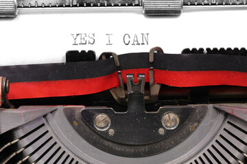 typewriter with a message of affirmation YES I CAN symbolizing determination confidence and the...