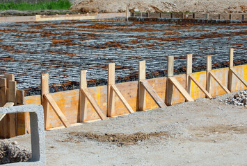 building formwork made with wooden planks during laying cement to make the foundation of the...
