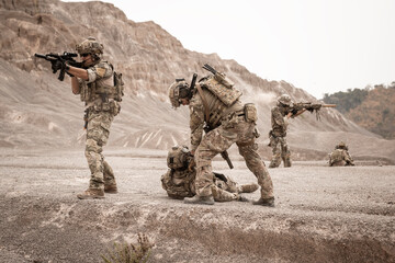 Soldiers in camouflage uniforms aiming with their rifles.ready to fire during military operation in...