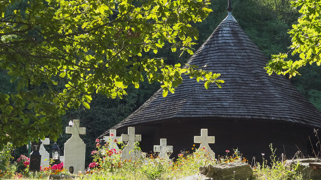 The ancient One Wood Monastery surrounded by cemetery white crosses, Valcea, Romania