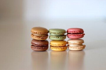 Stacks of colorful macarons on white table. Selective focus.