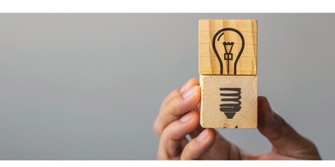 Hand holding a wooden block with a light bulb, concept of idea, creativity. - obrazy, fototapety, plakaty