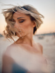 An artistic blur effect highlighting a mysterious woman with her hair tousled by wind