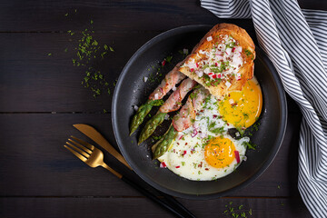 Keto breakfast. Fried eggs  with asparagus in bacon and toast. Top view, flat lay - 782318464