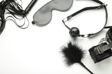 Set of erotic toys for BDSM on white background. The game of sexual slavery with a whip, gag and leather blindfold. Intimate sex games