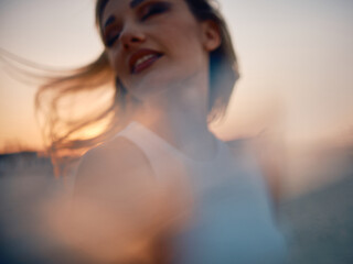 Artistic, blurred image capturing the essence of a carefree woman during a picturesque sunset