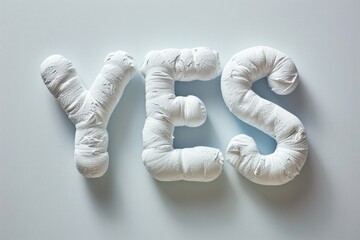 The word "YES" in a puffy, plush white texture against a clean background, giving a soft and positive impression.