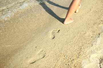 A Feet and footprints by the seashore in nature travel vacation background
