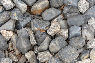 Heap grey stone for design in park and garden. Geometric pebbles close-up. Texture gravel and nature stone background. Roundish mineral.