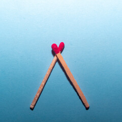 Heart made from matches creative love concept on blue background. Flat lay. 