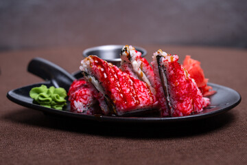 Delicious sushi rolls with caviar, wasabi soy sauce on plate closeup
