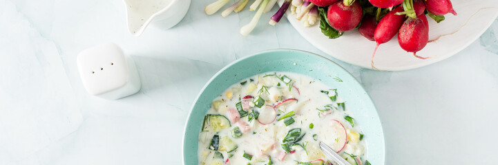 Cold summer soup Okroshka banner, soup with vegetables and sausage, eggs and fresh herbs and yogurt, traditional Russian soup