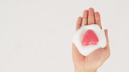 Hand washing with foaming and pink soap on white background.