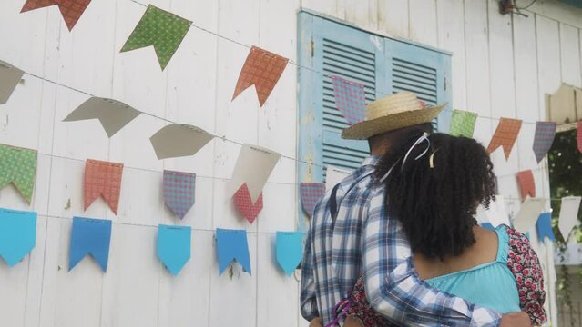 Festa Junina: party in Brazil, back of brazilian couple walking at arraial event in caipira style