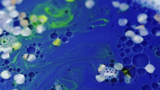 Flower essence. Gel fluid. Defocused blue white green neon color natural blossom glitter texture mix stripe oil bubble circle abstract background.