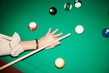 Close up of unrecognizable man playing billiard at green pool table with camera flash copy space