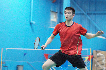 A very focused player plays single badminton.