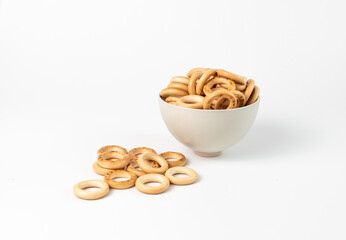 bread rings are laid out in a ceramic bowl on a white background