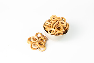 top view of bread rings laid out in a ceramic bowl on a white background