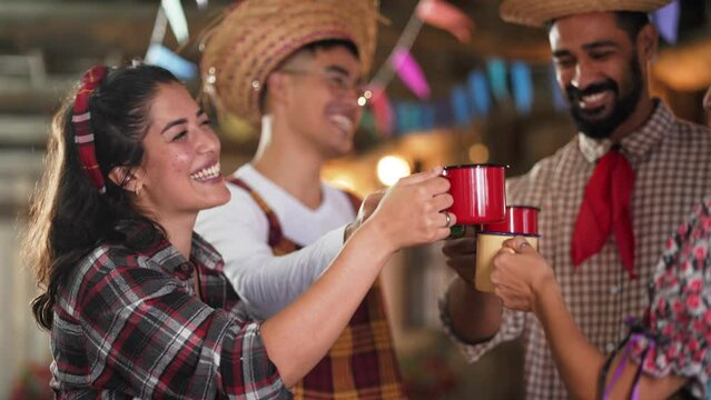 Celebratory Clinking of Cups by Joyous Friends at Brazilian June Festival. Smiling Trio Engaging in Traditional Festa Junina Toast in Rustic Setting