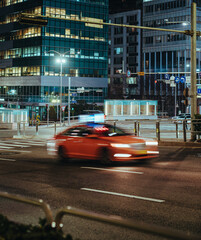 Taxi driving down a street in Seoul at night, blurred motion