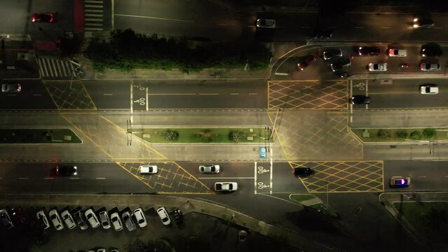 Cars passing by couple intersections with traffic safety paintings and traffic lights, Aerial top view 
