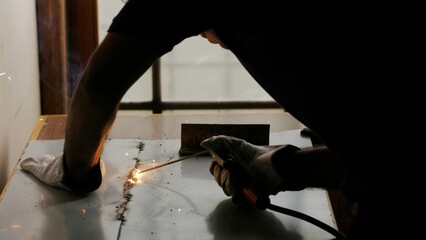 Worker welding metal in a workshop