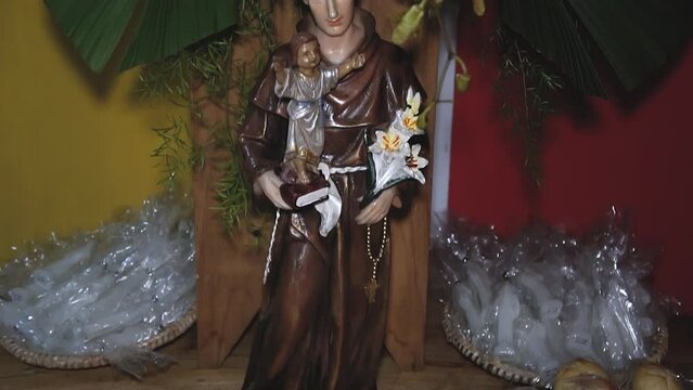 statue of Saint Anthony on a table decorated with bread