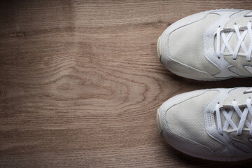 Natural suede white sneakers on wood table