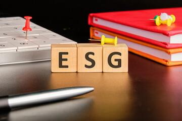 ESG concept of environmental, social and governance. words ESG on wooden cubes with a calculator...