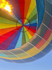 Colorful hot air balloon in the sky, with the gas burner turned on