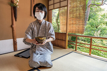 Japanese Green Tea Ceremony.
Woman serving traditional Japanese Matcha bowl.
