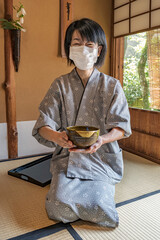 Japanese Green Tea Ceremony.
Woman serving traditional Japanese Matcha bowl.
