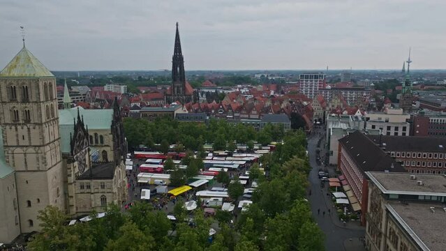 An aerial drone shot of St. Paulus Dom, also known as M&uuml;nster Cathedral, on Domplatz in M&uuml;nster on a sunny day. It is a central and culturally significant area of central M&uuml;nster, Germany. Busy Market