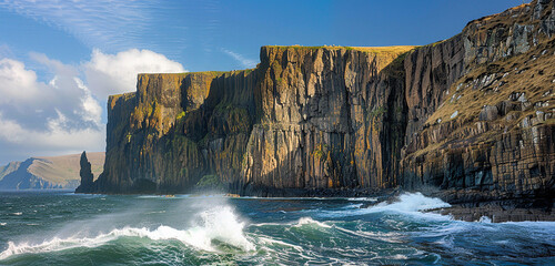 Dramatic natural beauty is created by the untamed cliffs of Neist Point, which tower majestically above the roaring seas below. The sea's unrelenting fury has worn away at the stony sides of these 
