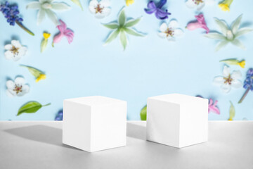 bright cosmetic soft blue floral background with geometric shapes. Two cement cubic podiums. Mockup for the demonstration of cosmetic products